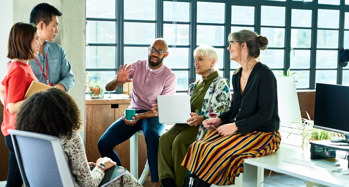 Image of a group of diverse people talking in a work setting